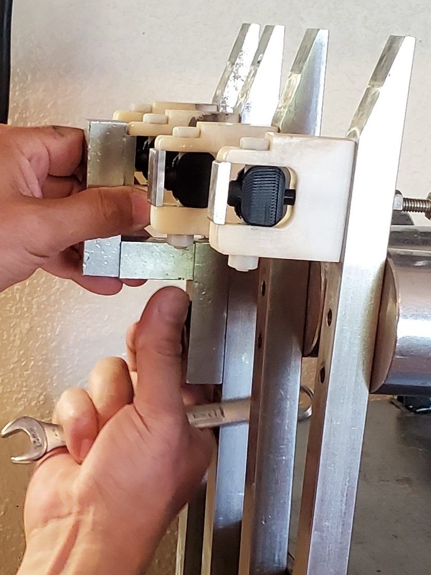 Hands adjusting components on a slurry testing apparatus